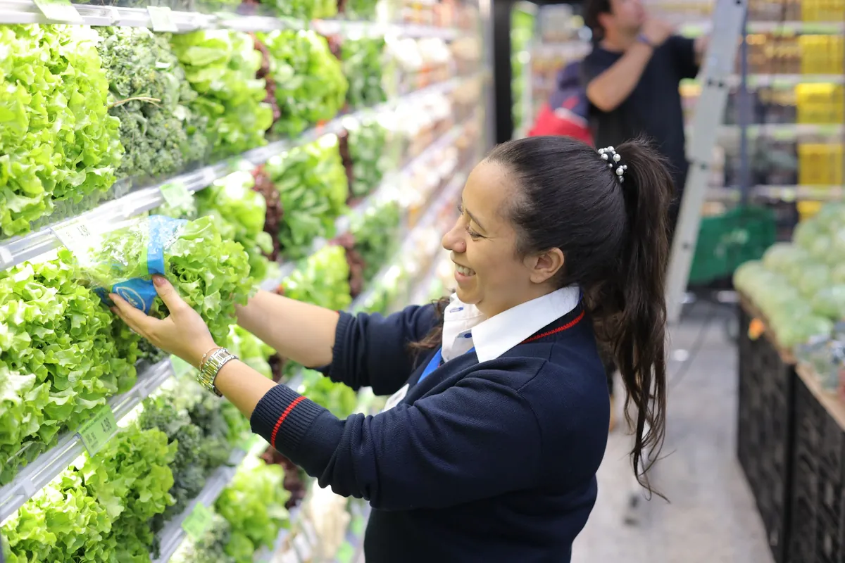 Colaboradora arruma alfaces no hortifruti do Nagumo