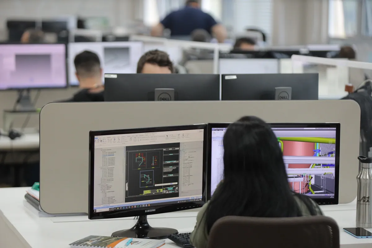 Profissional trabalhando em um projeto de engenharia na tela de dois monitores