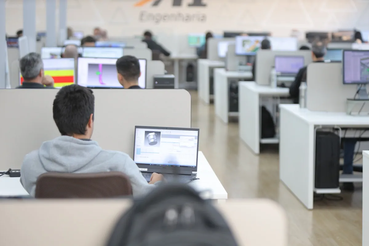 Equipe de engenharia trabalhando em um escritório aberto, com estações de trabalho enfileiradas